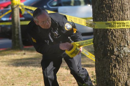 UALR police officer Sgt. James Heath tapes off an area near the theater building on campus where a student was shot.