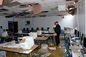 James M. Warren, with the Pulaski County Special School District surveys the damagein the computer lab at Sylvan Hills High School on Friday. SHHS suffered damage due to a possible tornado late Thursday evening.