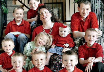 Wearing her charm necklace, Michelle Duggar, matriarch of the Duggar family of Springdale, enjoys a moment
with some of her children (top, left to right) Jedidiah, 9; Joy Anna, 10; Joseph, 13; (center row, from left) Jackson,
3; Johannah, 2; Jennifer, 8 months; Josiah, 11; (bottom row, from left) Justin, 5; Jason, 8; and James, 6.