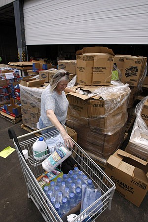 Storm victim Claudia Randall of Benton picks up household items and food Friday at the Arkansas Rice Depot in Little Rock.