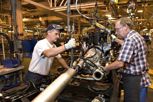 Workers place an engine in a pickup frame at the General Motors assembly plant in Oshawa, Ontario, in this file photo.