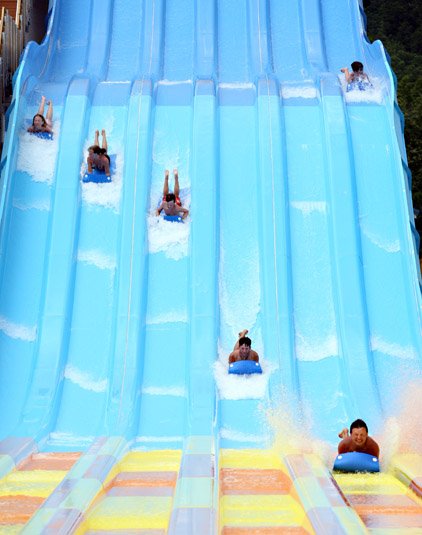 Park goers slide headfirst down the Rapid Falls Raceway at Magic Springs & Crystal Falls in Hot Springs. The raceway is new this year. 