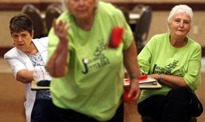 Brenda Glover (left), a member of the Hays Center Midlife Retreads, and Lou Vincent, with the Jacksonville Jitterbugs, try to see if Ann Pendergraft's toss scores during a June 10 game of beanbag baseball at the Patrick Henry Hays Senior Citizens Center in North Little Rock.