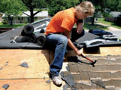 Megan Wilson of Duluth, Ga., removes old roofing nails at a home on Shelly Drive in Little Rock while volunteering with World Changers on Tuesday afternoon. The nonprofit organization will be in Little Rock this week to make repairs to homes for the city's elderly and disabled.