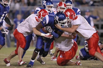 Bryant's Dijon Benton (middle) is brought down by Cabot players Jordan Carlisle (#11) and Michael James (#14)  in this 2007 file photo. 