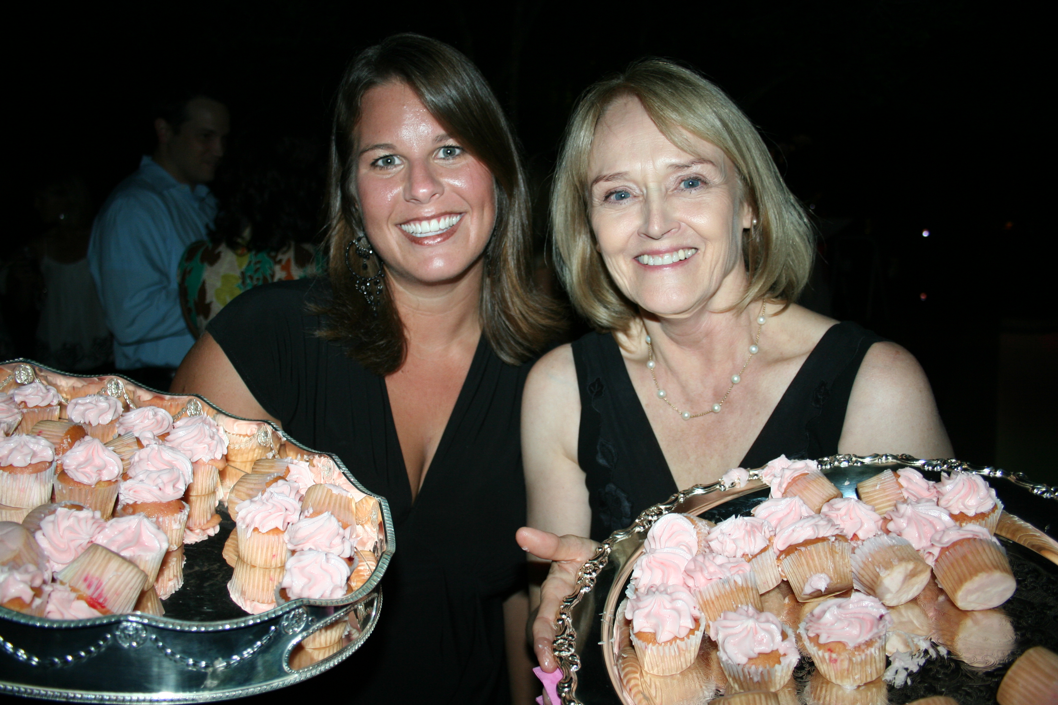 52. Emily Story and Sherrye McBryde serve pink cupcakes to the crowd.
