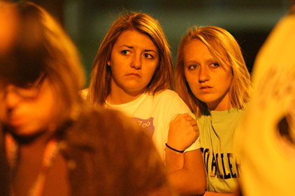 Candice Young (left), a former UCA student, and student Rene Hooper listen to a police news conference Sunday night about a fatal shooting on the campus earlier in the evening. 