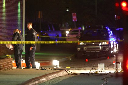 Police officers investigate the scene of a fatal shooting on the campus of the University of Central Arkansas. 