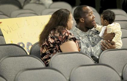 Sgt. Jermell Heath of Texas holds daughter, Jenesis, after she and his wife, Joeanna, attended a 39th Infantry Brigade welcome-home ceremony Wednesday night at Camp Shelby, Miss.