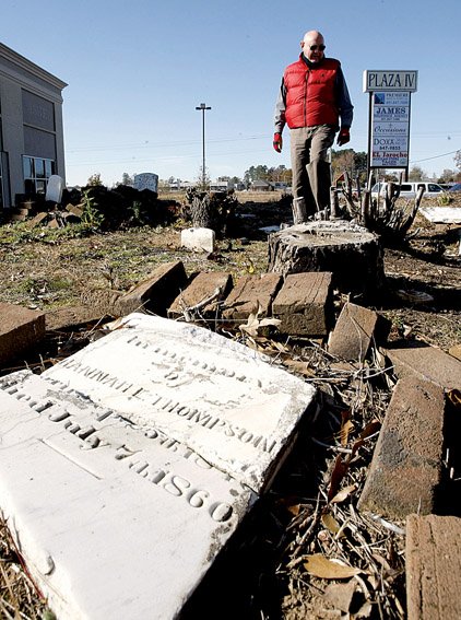 George Gatliff looks at the remains of a forgotten cemetery at Market Place Avenue and Arkansas 5 in Bryant. Gatliff and friend Meeks Etchieson have made a hobby of documenting lost graves.
