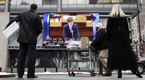 Pedestrians stop to watch a live broadcast Thursday in downtown Chicago of impeached Illinois Gov. Rod Blagojevich delivering his closing argument in Springfield, Ill.