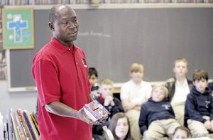 Thomas Awiapo holds up the cardboard "rice bowl" that benefits people worldwide.