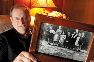 John Karolson shows a 1950 photo of himself (far right) and his family while living at Camp K military barracks in Immendorf, Germany. 