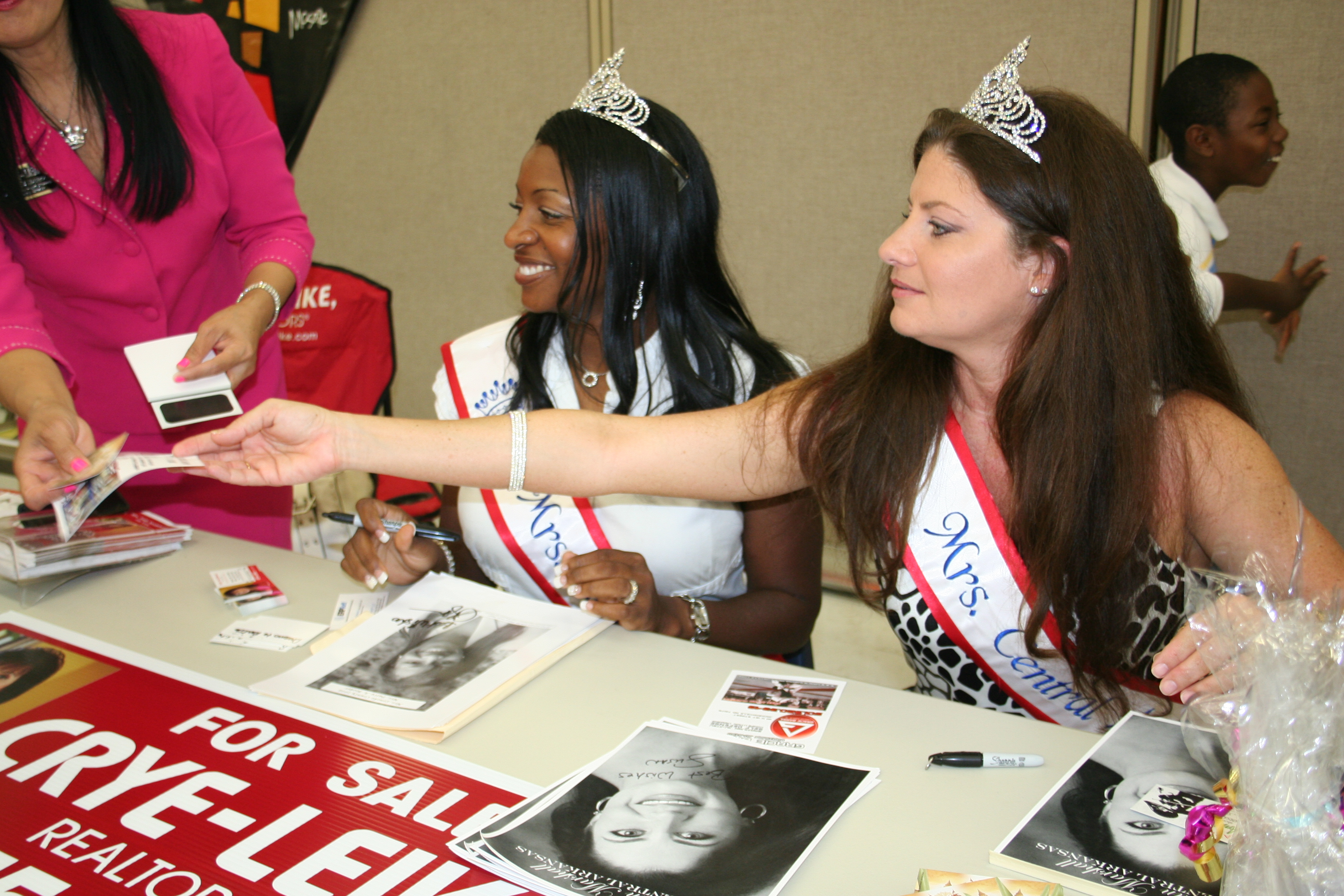Mrs. Patty Booker and Mrs. Susan Marshall both contestants in the Mrs. Arkansas pageant sign autographs.