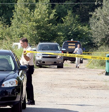 Pulaski County sheriff's deputies work the scene on Dick Jeter Park Road where a burned body was found Tuesday afternoon, about 600 yards from where the pickup belonging to missing former Waldron Mayor Troy Anderson was found June 25.