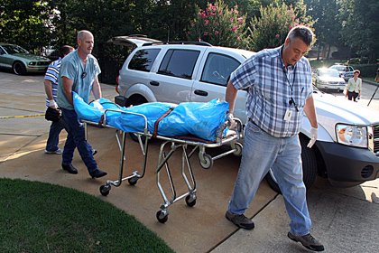 The body of Todd Bostian is removed from near the home at 144 Blue Heron Drive on Lake Hamilton in Hot Springs on Friday morning.