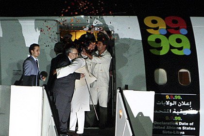 A crowd threw flower petals at Abdel Baset al-Megrahi (left) as he was hugged by Seif al-Islam el- Gadhafi, son of Libyan leader Moammar Gadhafi upon his arrival at airport in Tripoli, Libya, on Thursday, Aug. 20, 2009. 