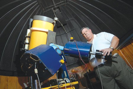 Doug Matthews, a dentist in Batesville, studies astronomy in his backyard observatory with a 14-inch telescope. 