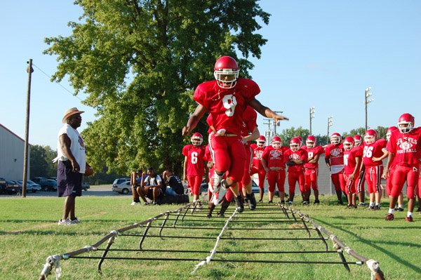 Antoine Mosby leaps through the ropes during practice as teammates line up to follow. 