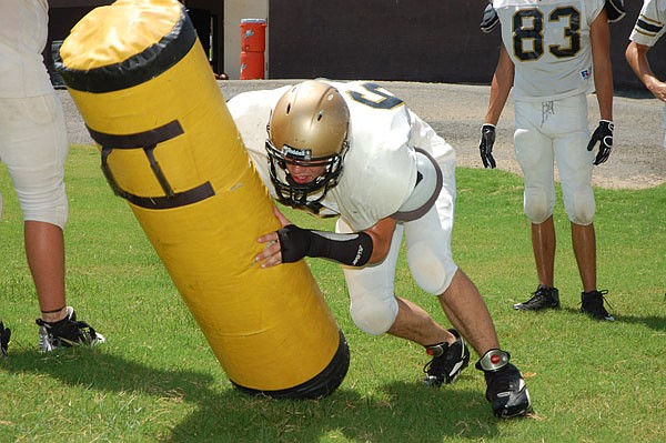 Chase Roberson lays a hit on a tackling dummy. 