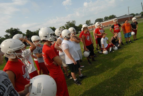 The Red Devils listen intently to head coach Charlie Sorrells at the end of practice. 