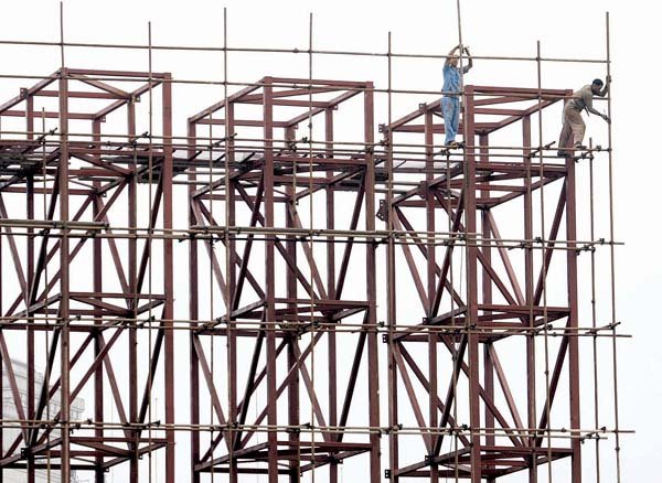 Chinese construction workers set up scaffolding around a steel structure ahead of the 60th national day celebrations held Monday in Beijing.