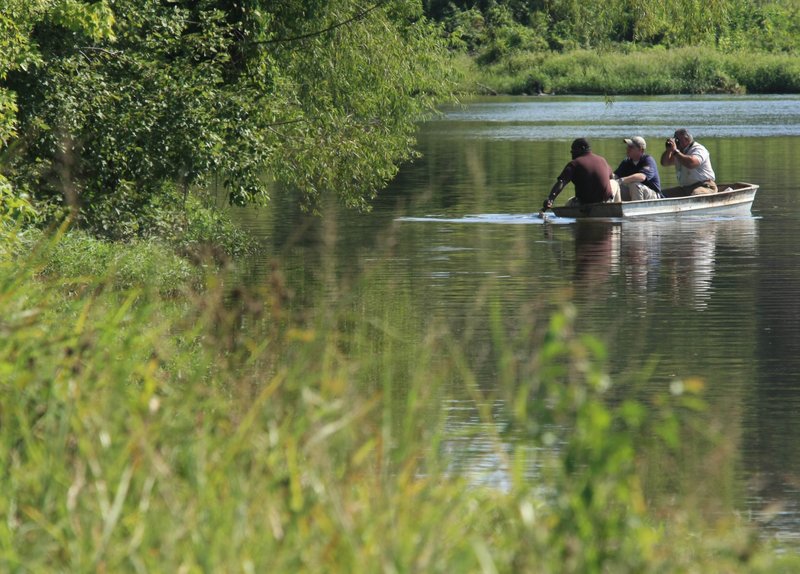 nvestigators including Pulaksi County Chief Deputy Coroner Gerone Hobbs (left) make their way Tuesday afternoon to an area in a pond on Matt Road where a body was found.