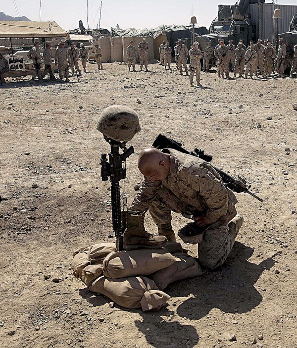 A U.S. Marine pays his respects to a fallen comrade, killed earlier this month in a Taliban ambush, during a memorial service Thursday at a forward operating base in Now Zad in Afghanistan's Helmand province.