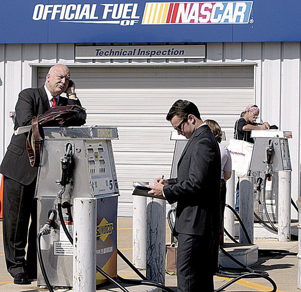 A man uses a gas pump as a desk during a job fair at New Hampshire Motor Speedway on Thursday in Loudon, N.H.