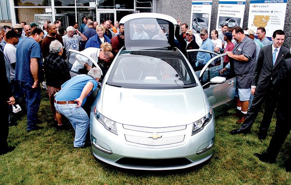 General Motors employees look over a 2011 Chevrolet Volt plug-in hybrid Friday at its powertrain plant in Bay City, Mich., after GM announced a $37 million investment to produce engine parts at the plant.