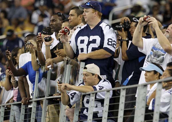 Dallas Cowboys fans line up to take pictures of players during practice Thursday at Cowboys Stadium in Arlington, Texas. Fans were admitted free for the practice session.