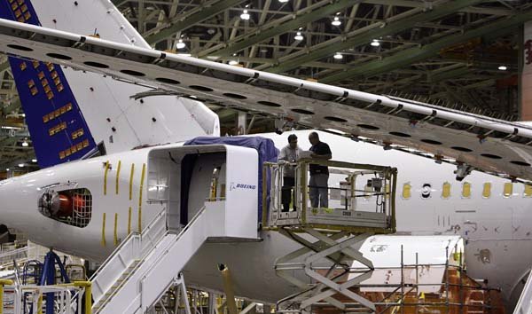 Boeing employees work near the wing of a 787 test plane at Boeing's plant in Everett, Wash., in April.