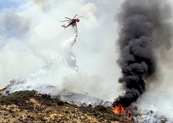 A helicopter drops water on a hot spot in the Angeles National Forest near Los Angeles on Sunday.