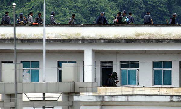 Burmese soldiers man a rooftop on the Burma side as seen from the Chinese border town of Nansan in southwestern China's Yunnan province on Sunday. 