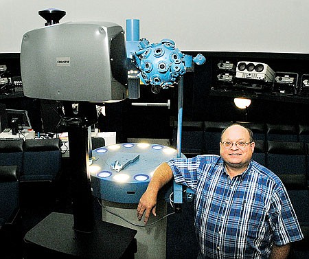 Planetarium manager Jim Duke stands by the new digital projector at Henderson State University. The projector uses a fish-eye lens to project across the planetarium dome.