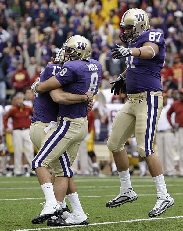 Washington kicker Erik Folk and holder Ronnie Fouch celebrate with teammate Romeo Savant after defeating Southern California on Saturday. The victory propelled Washington into the AP Top 25 for the first time since 2003. The Huskies are ranked No. 24.