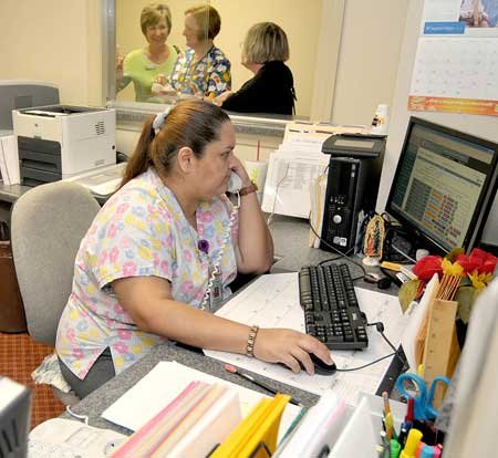Maria Zamarripa, a health-services specialist, answered phones and made appointments during the grand opening of the Benton County Health Department's new satellite office in Siloam Springs on Monday. 