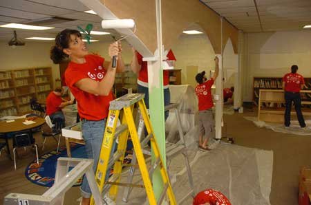 Volunteer Daisy Nelson paints some arches Friday in the library at Asbell Elementary School in Fayetteville. Nelson joined dozens of other Target employees at the school to give the library a $3,000 makeover. 