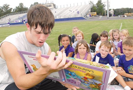 Riverview football player Greg Parvin reads to Mrs. Parkers' kindergarten class at the Riverview High School football stadium.