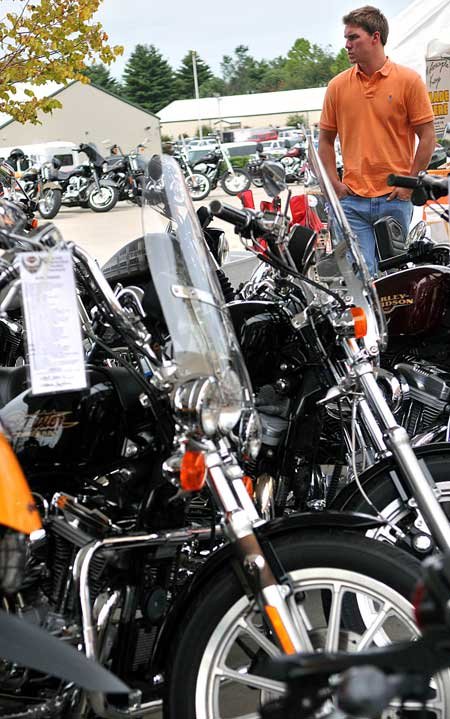 Todd White of Bentonville looked at some motorcycles that were for sale outside of Pig Trail Harley-Davidson in Rogers on Wednesday. 