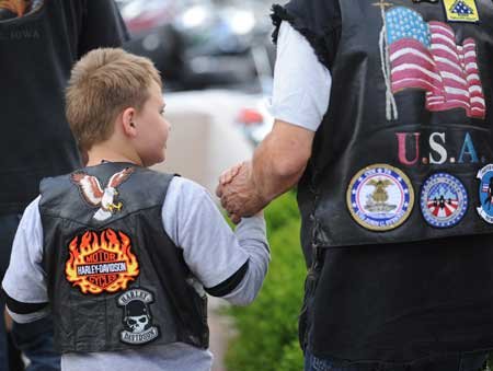  Mickey Curtis of Tulsa, Okla., holds the hand of his grandson, Joseph, 8, while walking down West Dickson Street on Saturday in Fayetteville. 