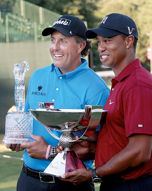 Phil Mickelson and Tiger Woods hold the trophies for winning the Tour Championship and FedEx Cup, respectively.
