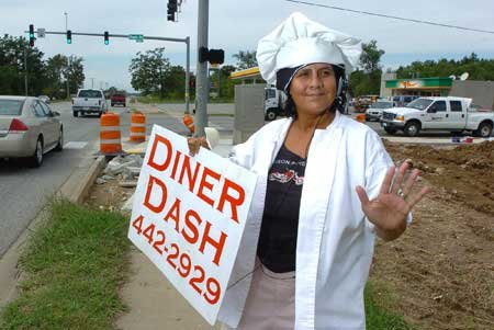 Sandra Barth dances Thursday in front of Diner Dash on Wedington Drive in Fayetteville. Barth, who works for owners Tommy and Nikki Golden, dances to bring in customers and because she enjoys it. 