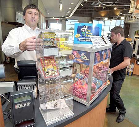 Tim Pennington, left, pulled out some scratch-off tickets for Calvin Clary at the White Oak Station on Southwest Regional Airport Boulevard in Bentonville on Monday.