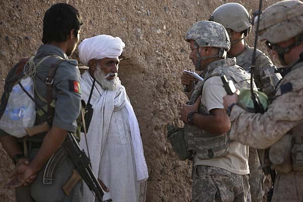 Afghan-American translator Waheed Kazenpoor of California translates Monday for U.S. troops as they speak with a local villager during a joint Afghan-U.S. patrol in an area frequented by Taliban militants in the Nawa district, Helmand province, of southern Afghanistan.