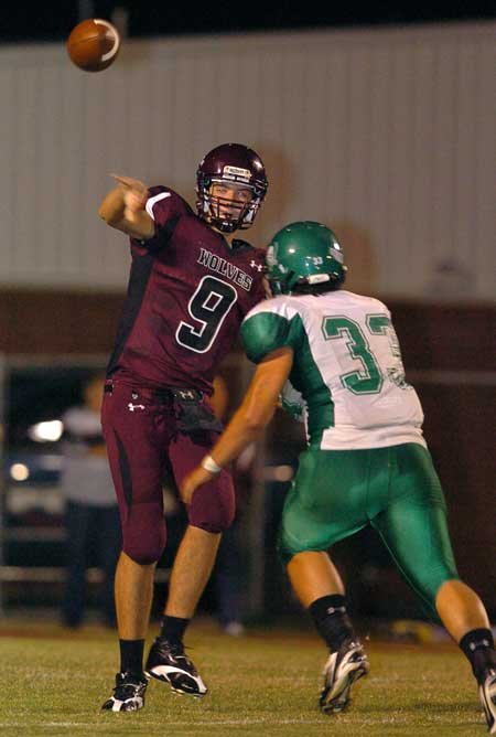 Lincoln quarterback Zach Summers (9) throws the ball away before being tackled by Greenland's Jeremy Huber (33) during play at Lincoln, Sept. 25. 