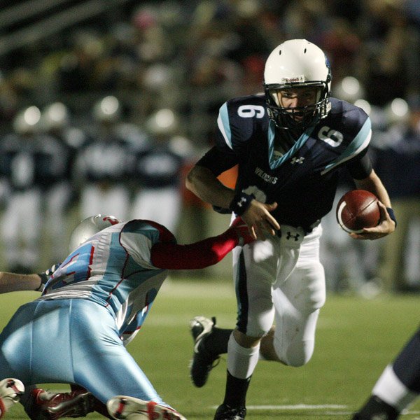 Springdale Har-Ber quarterback Ryan Luther has his jersery grabbed by Fort Smith Southside's Daniel Berry Friday.