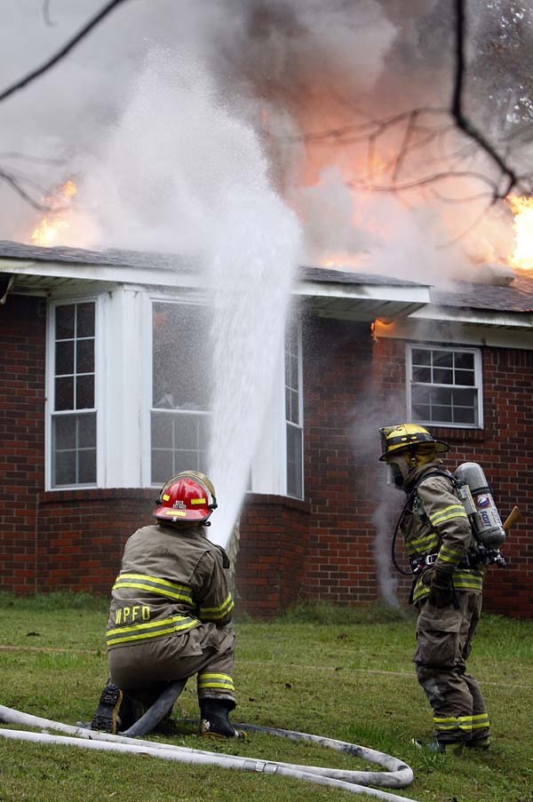 Volunteer firefighters battle a house fire Tuesday at 13810 Colonel Glenn Road in Pulaski County. The structure was a total loss, officials said. No injuries were reported. 