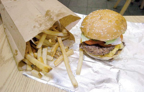 Eat in or take out, Five Guys customers dine out of a brown paper bag.