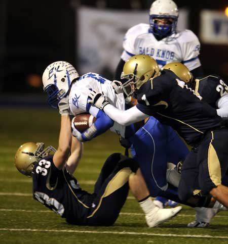 Shiloh Christian linebackers Colt Thomas, bottom, Mitchell Roberts, center, and Chase Richards tackle Bald Knob wide receiver Jordan Johnston during the first half of Friday’s game in Champions Stadium in Springdale.